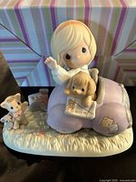 Full view of Precious Moments figurine showing girl in car, puppy, kitten and mouse