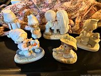 Group of six Precious Moments figurines on table