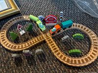 assembled figure-eight track with cars, barn, trees, sign, supports