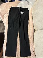 Full view of black Apricoat Adventure Pants laid flat