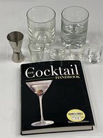 Full lot overview: book, jigger, rocks glasses, shot glasses
