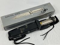 Knife in sheath beside original IPCS box showing SURVIVAL KNIFE branding