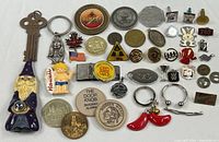 All items laid out showing variety of pins, tokens, keychains and magnets