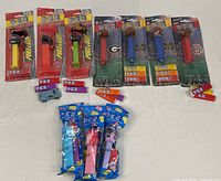 Group shot of all PEZ dispensers, showing four Pull & Go, five College Football, three My Little Pony, loose blue vehicle and candy packs
