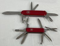 Both Swiss Army knives open showing tools