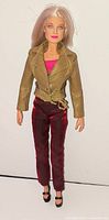 Full-length view of the Natalie Barbie doll wearing jacket, pink top, red pants and black shoes