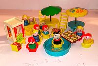 Lot overview showing Little People figures with patio furniture, pool, grill and booth