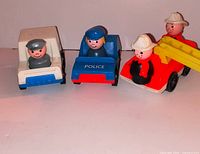 Group shot showing three vintage Fisher-Price vehicles with four matching Little People figures and ladder