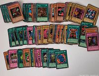 Spread of all Yu-Gi-Oh cards in lot showing fronts and variety of Monster, Spell, Trap cards