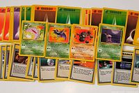 Array of Pokémon, Trainer and Energy cards fanned out on white surface
