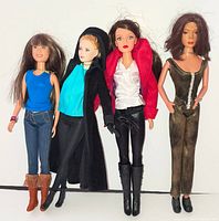Four 12-inch fashion dolls standing side by side displaying full outfits and hair styles
