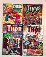 Front view of four Thor comics laid out showing full covers and issue numbers