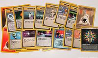 Spread of all visible trainer and energy cards to show variety and condition