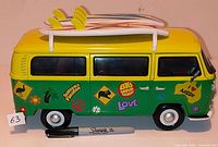 Left side view of van showing decals, surfboards on roof, Sharpie for scale