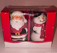 Boxed pair of Santa and Snowman ceramic shakers front view
