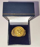 Ring in navy presentation box showing coin face