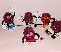 Group of five California Raisins PVC figurines showing fronts and accessories