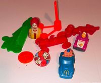 Group shot of all McDonald’s toys including bust, cars, comb, spinner, token and red parts