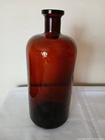 Full view of amber glass apothecary bottle standing upright