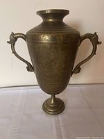 Full view of brass urn showing overall shape, handles, pedestal base