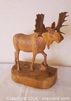 Front/side view of hand-carved wooden moose on base