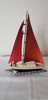 Full view of sailboat lamp showing red lucite sails and aluminum base