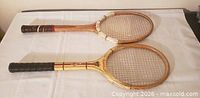 Both vintage wooden rackets side by side showing full length and heads