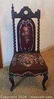Front view showing carved crest, barley twist uprights, floral needlepoint upholstery, cabriole legs