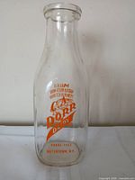 Front view showing C.A. Dorr Dairy name, phone number, Watertown, N.Y. and orange print