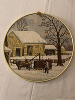 Front view of circular fabric wall art in brass frame