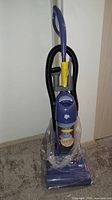 Full view of Dirt Devil Vibe upright vacuum still in protective plastic
