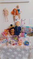 Overall view of all dolls, pony pack, shoe packs on lace-covered table