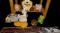 Group shot showing all ceramic figurines, coin banks, novelty items on and in front of small wooden shelf