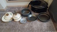 Full lot overview showing casseroles, pans, baking tin, Crock-Pot