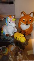 Unicorn and fox cookie jars beside bee honey dish