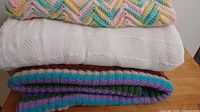 Stacked view of all three blankets showing colors and textures