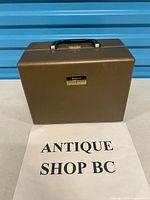 Closed hard carrying case front view with handle and Argus badge