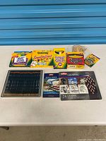 All items laid out on table showing Derwent tin, Crayola packages, clothespins