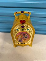 Front view of closed vanity with Belle and Ariel graphic, faux jewels and handle visible