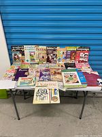 Full lot displayed on folding table showing all magazines and books
