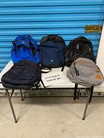 Front view of all five backpacks on table