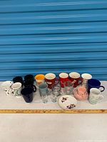Full lot showing mugs, shot glasses, plates on table