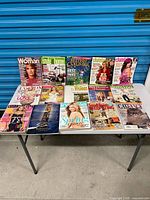 Full view of approximately 15 magazines laid on table