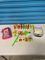 All items grouped on table: 10 PEZ dispensers, Barbie pouch, tin of stars, Merida toy