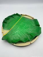 Top view showing banana-leaf platter on woven tray