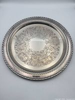 Full view of round engraved silver-plate tray