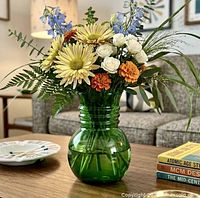 Vase displayed with flowers on coffee table
