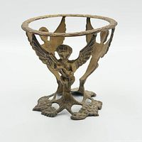 front view showing four winged cherubs and circular ring