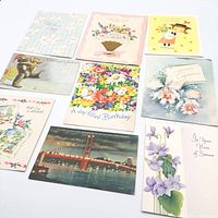All nine vintage greeting cards and postcard laid out in three rows