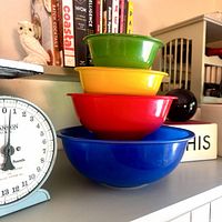 Stacked set of four primary-color Pyrex bowls on shelf